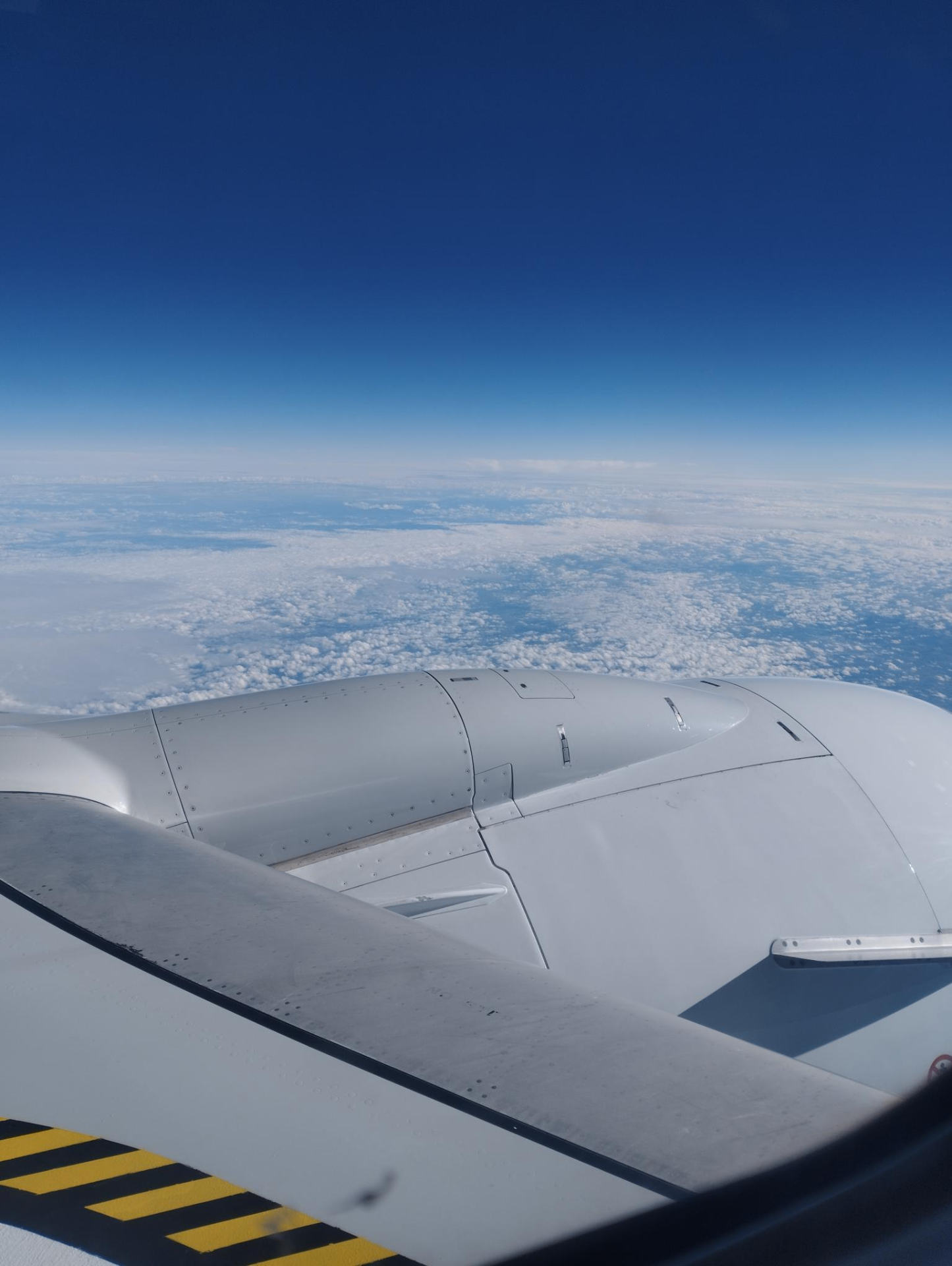Uitzicht vanuit een vliegtuigraam op een wolkendek en een vleugel — onderweg naar Thessaloniki